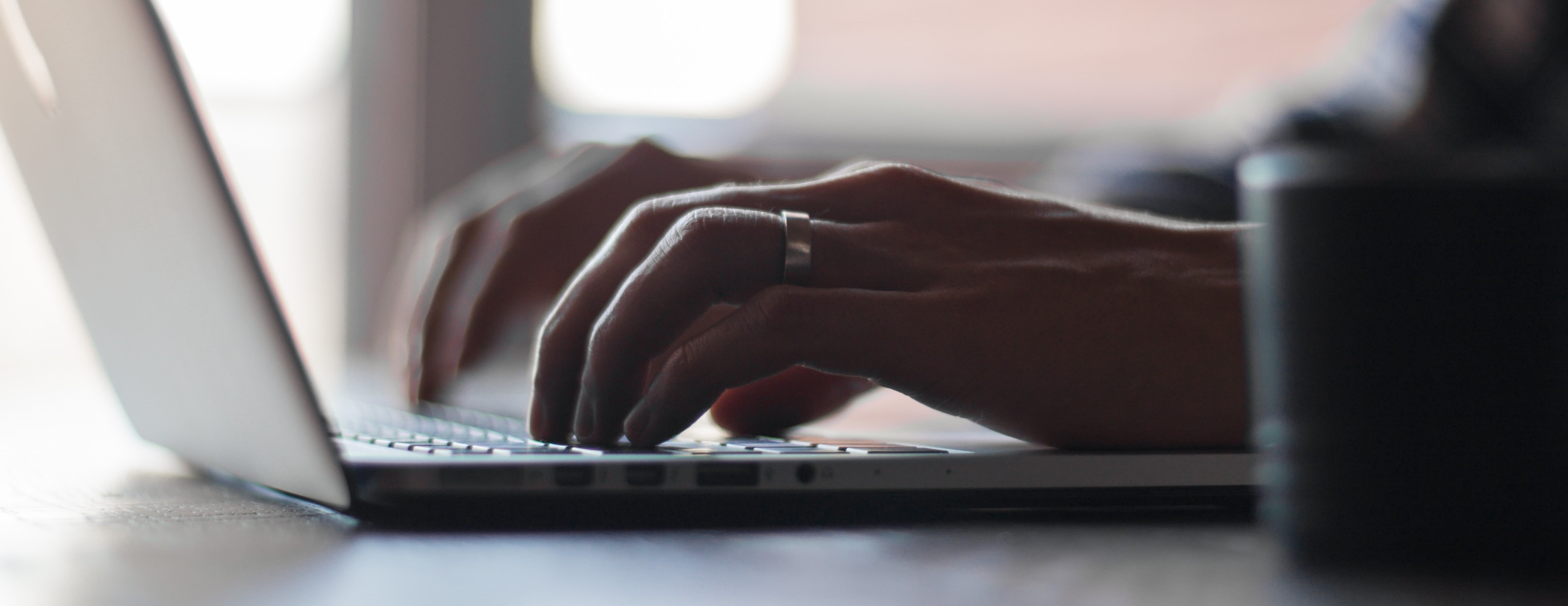 Hands typing on computer